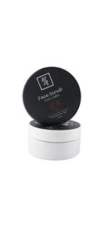 Face scrub container with black lid and white body on a white background